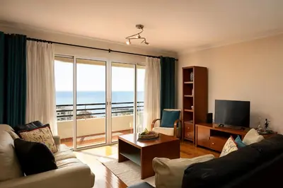 a living room with a view of the ocean at Margarida's Apartment com piscina e vista mar in Funchal