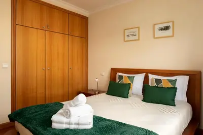 a bedroom with two beds with green and white towels at Margarida's Apartment com piscina e vista mar in Funchal