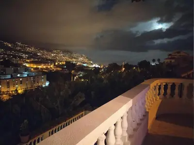 a view of a city at night from a balcony at Casa Alencastre in Funchal