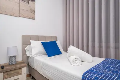 a bedroom with a bed with blue and white pillows at Blue Paradise Apartment in Caniço