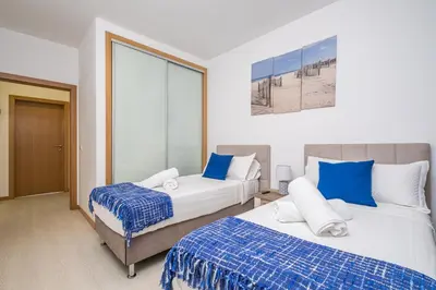 a bedroom with two beds with blue and white sheets at Blue Paradise Apartment in Caniço