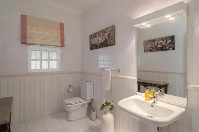 a white bathroom with a sink and a toilet at OurMadeira - Villa Vista Sol in Funchal
