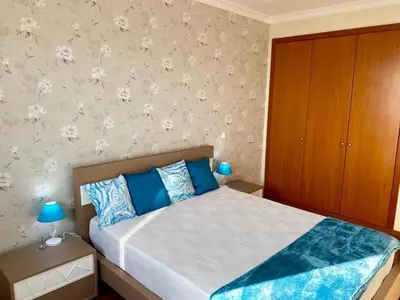 a bedroom with a bed with blue pillows at Canico Penthouse with Sea View in Caniço