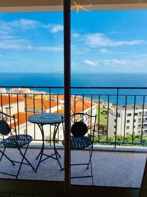 a table and chairs on a balcony with a view of the ocean at Canico Penthouse with Sea View in Caniço