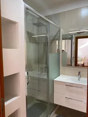 a bathroom with a glass shower and a sink at Canico Penthouse with Sea View in Caniço