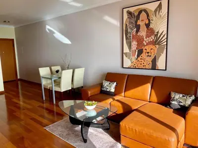 a living room with a couch and a glass table at Canico Penthouse with Sea View in Caniço