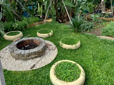 a garden with a fire pit in the grass at Tabua Village Madeira Suite VIP in Ribeira Brava