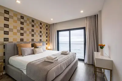 a bedroom with a large bed with a large window at Sea View Balcony by Homie in Santa Cruz