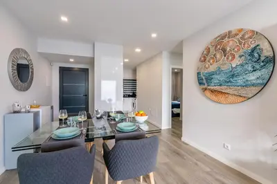 a dining room with a glass table and chairs at Sea View Balcony by Homie in Santa Cruz