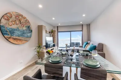 a dining room with a table and chairs and a couch at Sea View Balcony by Homie in Santa Cruz