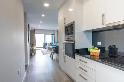 a kitchen with white cabinets and black counter tops at Sea View Balcony by Homie in Santa Cruz