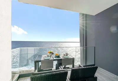 a dining room with a table and chairs and the ocean at Sea View Balcony by Homie in Santa Cruz