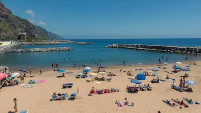 a group of people on the beach at a beach at Madalena Beach Tiny House in Ponta do Sol