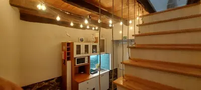 a room with a refrigerator and a staircase with lights at Madalena Beach Tiny House in Ponta do Sol