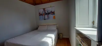 a small bedroom with a white bed and a window at Madalena Beach Tiny House in Ponta do Sol