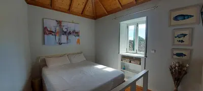 a small bedroom with a bed and a window at Madalena Beach Tiny House in Ponta do Sol