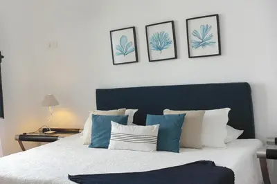 a bedroom with a bed with blue and white pillows at Casa Azul - Ocean View in Porto Moniz