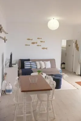 a living room with a table and chairs and a couch at Casa Azul - Ocean View in Porto Moniz