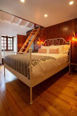 a bedroom with a bed with a wooden wall at Madeira Black Sand House by Stay Madeira Island in Seixal