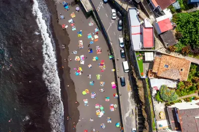 an overhead view of a beach with umbrellas at Madeira Black Sand House by Stay Madeira Island in Seixal