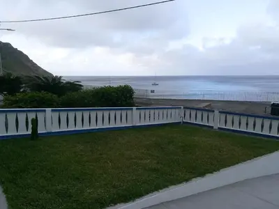 a view of the ocean from a house with a white fence at Alo Baía São Lourenço in Santa Bárbara