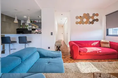 a living room with a blue couch and a red chair at Casa Familiar 3 Quartos in Funchal