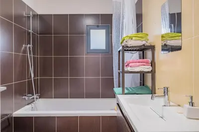 a bathroom with a tub and a sink and a mirror at Casa Familiar 3 Quartos in Funchal