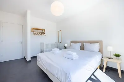 a bedroom with a large white bed with white pillows at Villa Botelha in Sagres