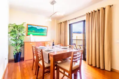 a dining room with a table and chairs and a window at LULINA Two Bedroom by ALMA Holiday Rentals in Funchal
