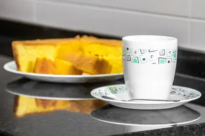 a coffee cup and a plate of cake on a counter at LULINA Two Bedroom by ALMA Holiday Rentals in Funchal