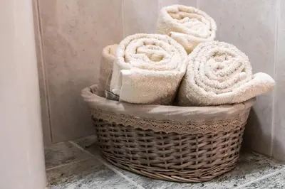 a basket filled with towels on a bathroom floor at LULINA Two Bedroom by ALMA Holiday Rentals in Funchal