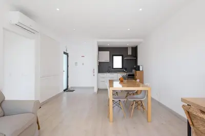a living room with a table and a kitchen at Villa Hobie Cat in Sagres
