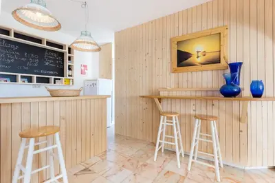 a kitchen with a counter with stools and a chalkboard at Ocean view beach villa in Budens