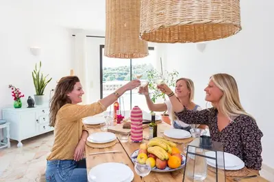 a group of women sitting around a table drinking wine at Ocean view beach villa in Budens