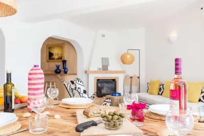 a wooden table with wine bottles and wine glasses at Ocean view beach villa in Budens
