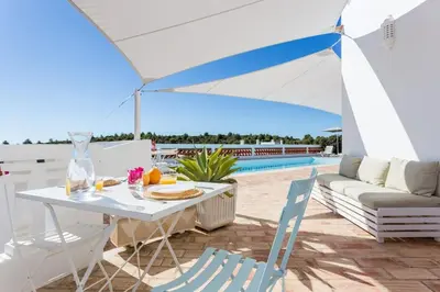 a patio with a table and chairs and a pool at Ocean view beach villa in Budens