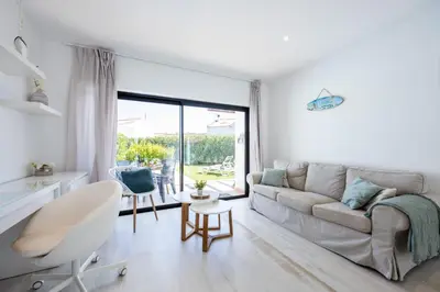 a white living room with a couch and a table at Villa Front Loop in Sagres