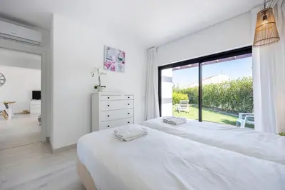 a bedroom with a large white bed and a large window at Villa Front Loop in Sagres