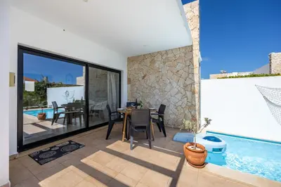 a villa with a swimming pool and a dining room at Villa Front Loop in Sagres