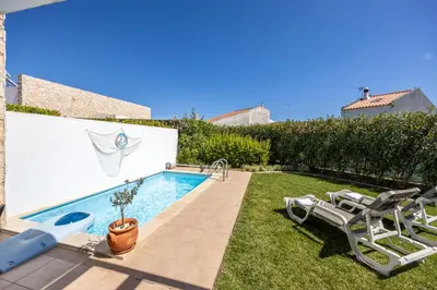 a backyard with a swimming pool and lawn chairs at Villa Front Loop in Sagres
