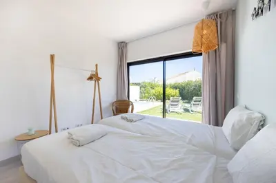 a bedroom with two white beds and a window at Villa Front Loop in Sagres