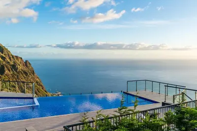 a swimming pool with a view of the ocean at OurMadeira - Sunset Cliff Villas in Fajã da Ovelha