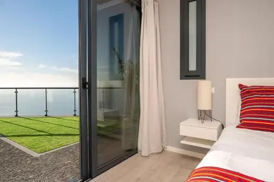 a bedroom with a bed and a view of the ocean at OurMadeira - Sunset Cliff Villas in Fajã da Ovelha