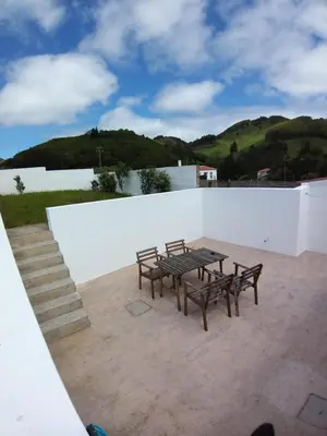 a table and benches on top of a white wall at Casa Malbusca in Almagrinha