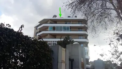 a tall building with a green arrow on top of it at Bright Studio in Funchal