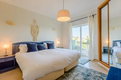 a bedroom with a large bed and a large window at Casa Lomy - Boavista Resort and Spa in Quatro Estradas