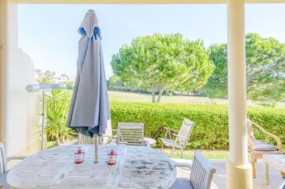 a table with an umbrella on a patio at Casa Lomy - Boavista Resort and Spa in Quatro Estradas