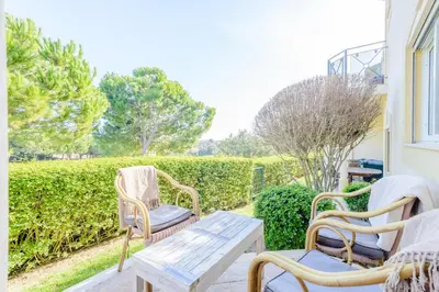 a porch with two chairs and a wooden table at Casa Lomy - Boavista Resort and Spa in Quatro Estradas