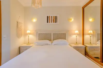a bedroom with a large white bed and two lamps at Casa Lomy - Boavista Resort and Spa in Quatro Estradas