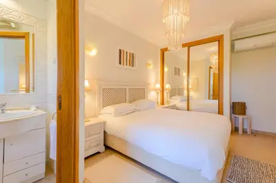 a bedroom with a white bed and a mirror at Casa Lomy - Boavista Resort and Spa in Quatro Estradas